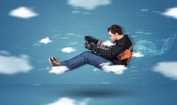 Grappige racedriver jonge man rijden tussen wolken begrip — Stockfoto