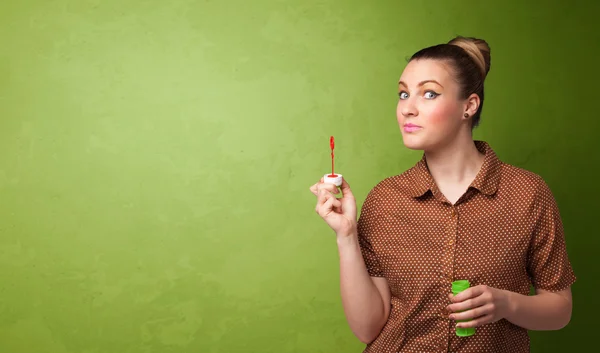 Hermosa mujer soplando burbuja de jabón sobre fondo de copyspace — Foto de Stock