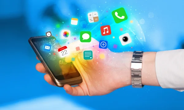 Main tenant smartphone avec des icônes d'application colorées — Photo