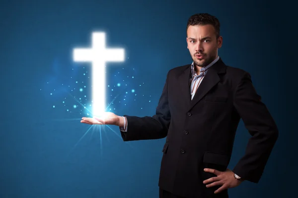 Glowing cross in the hand of a businessman — Stock Photo, Image