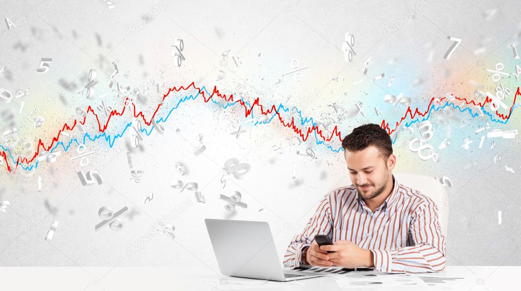 Business man sitting at table with stock market graph 