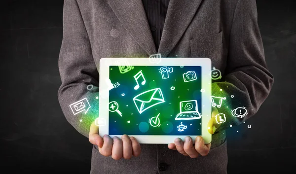 Person holding a tablet with media icons and symbols — Stock Photo, Image