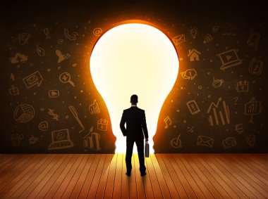 parlak ampul duvara bakarak iş adamı 