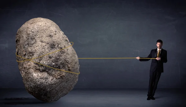 Бізнесмен тягне величезний камінь з мотузкою — стокове фото