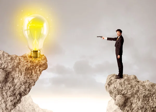Businessman on rock mountain with idea bulb — Stock Photo, Image