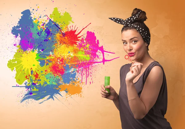 Graziosa ragazza soffiando colorato splash graffiti — Foto Stock