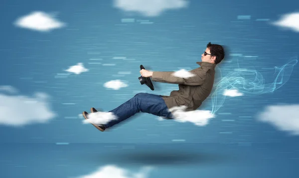 Funny racedriver young man driving between clouds concept — Stock Photo, Image