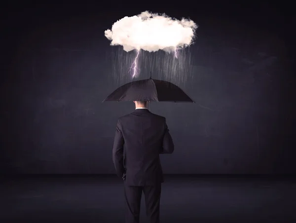 Businessman standing with umbrella and little storm cloud — Stock Photo, Image