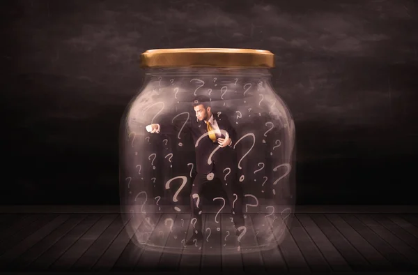 Businessman locked into a jar with question marks concept — Stock Photo, Image