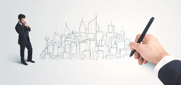 Businessman looking at hand drawn city on wall — Stock Photo, Image