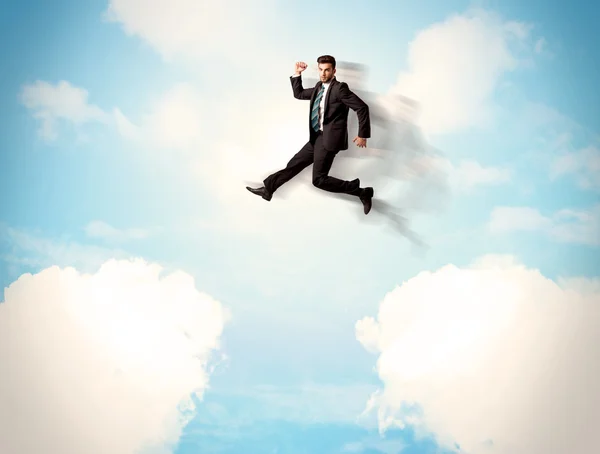 Uomo d'affari che salta sopra le nuvole nel cielo — Foto Stock