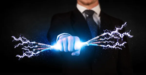 Business person holding electrical powered wires — Stock Photo, Image