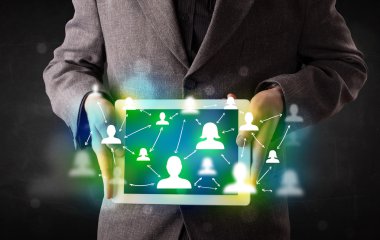 Yeşil sosyal medya simgeleriyle tablet sunan genç kişi