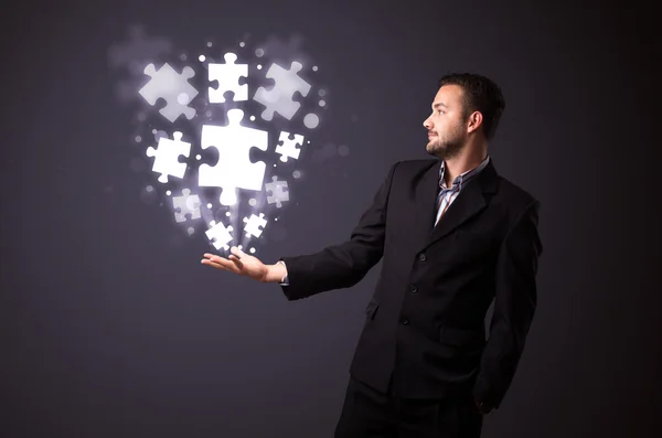 Puzzle pieces in the hand of a businessman — Stock Photo, Image