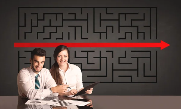 Business couple with a solved puzzle in background — Stock Photo, Image