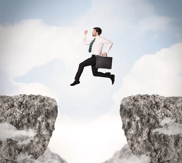 Funny business man jumping over rocks with gap — Stock Photo, Image