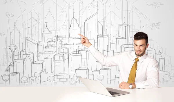 Businessman sitting at the white table with hand drawn buildings — Stock Photo, Image