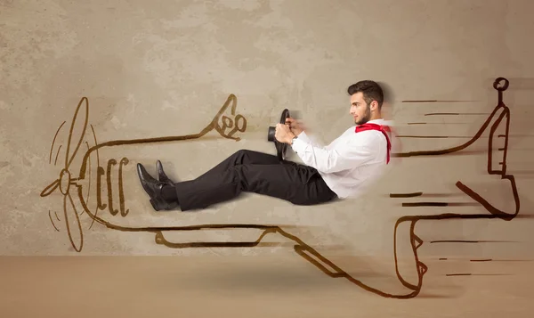 Funny pilot driving a hand drawn airplane on the wall — Stock Photo, Image