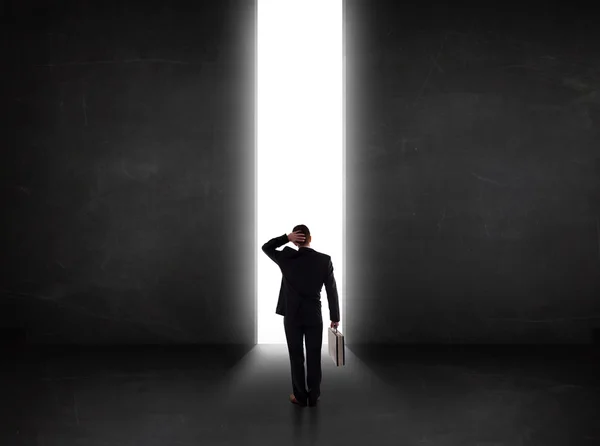 Business person looking at wall with light tunnel opening — Stock Photo, Image