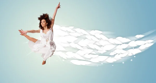 Здоровая молодая женщина прыгает с перьями вокруг нее — стоковое фото