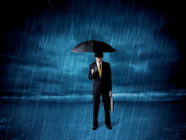 Homem de negócios de pé na chuva com um guarda-chuva — Fotografia de Stock