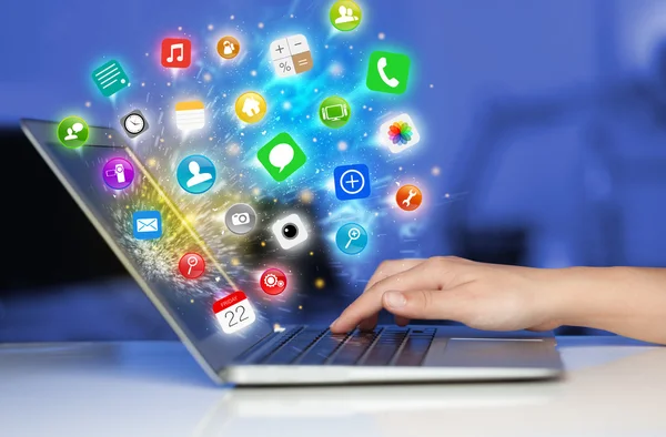 Hand drücken moderner Laptop mit mobilen App-Icons und Symbolen — Stockfoto