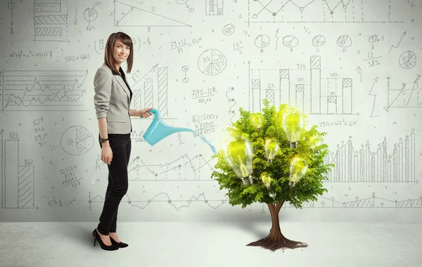 Business woman pouring water on lightbulb growing tree — Stock Photo, Image