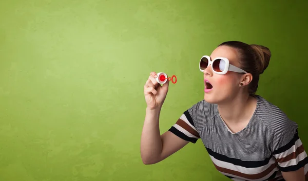 Hermosa mujer soplando burbuja de jabón sobre fondo de copyspace — Foto de Stock