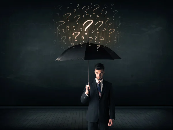Businessman with umbrella and a lot of drawn question marks — Stock Photo, Image