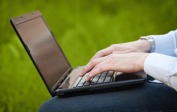 Geschäftsmann drückt modernen Laptop auf bunten Hintergrund — Stockfoto