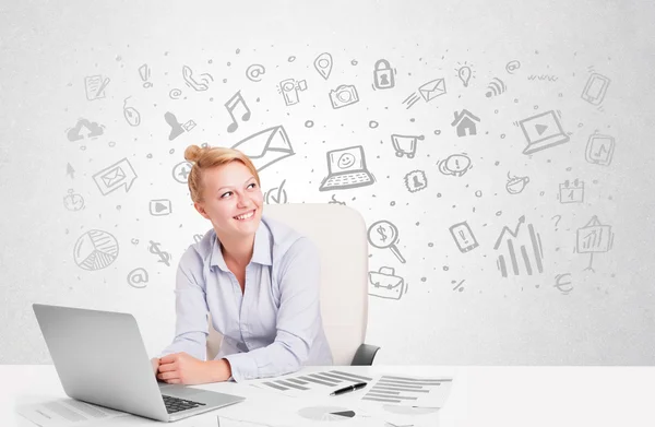 Business woman sitting at table with hand drawn media icons — Stock Photo, Image