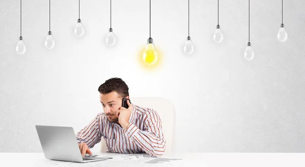 Zakenman zit aan tafel met idee gloeilampen — Stockfoto