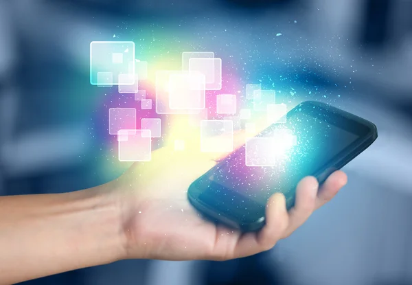 Hand holding smart phone with abstract glowing squares — Stock Photo, Image