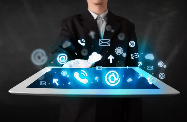 Persona sosteniendo una tableta con iconos y símbolos de tecnología azul —  Fotos de Stock