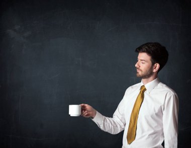 Beyaz bir bardak tutan işadamı