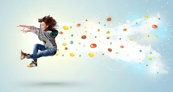 Женщина прыгает с разноцветными гемами и кристаллами на батуте — стоковое фото
