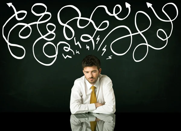 Depressed businessman sitting under drawn direction lines — Stock Photo, Image