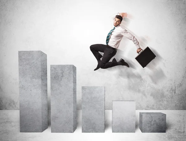 Successful business man jumping over charts on background — Stock Photo, Image