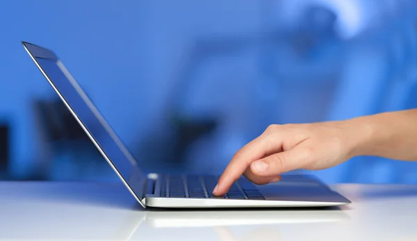 Empresário pressionando computador portátil moderno em backgrou colorido — Fotografia de Stock