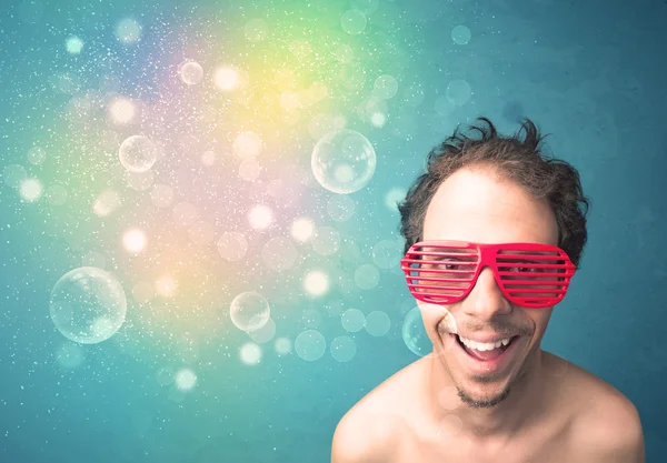 Ung man med solglasögon och bokeh färgglada lampor — Stockfoto