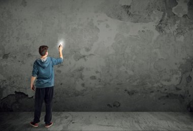 Genç şehir ressamı çizmeye başladı.