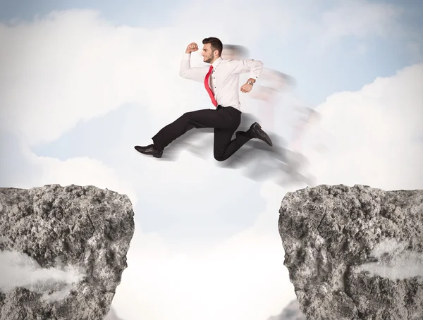 Funny business man jumping over rocks with gap — Stock Photo, Image