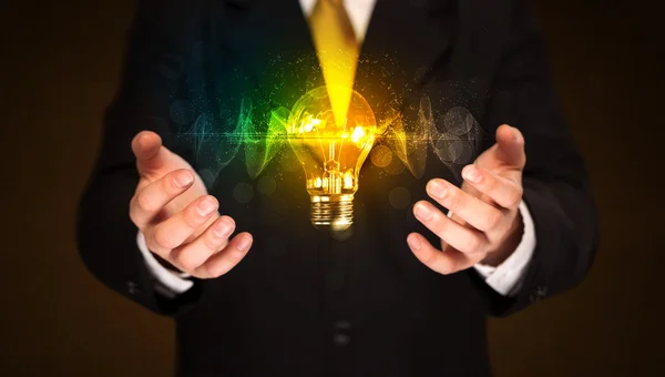 Businessman holding light bulb — Stock Photo, Image