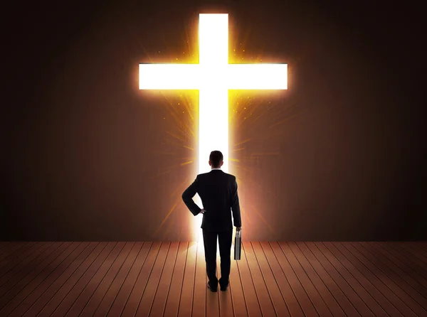 Человек смотрит на яркий знак креста — стоковое фото