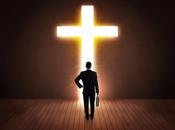 Man looking at bright cross sign — Stock Photo, Image