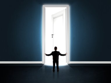 Büyük parlak kapıyı açan bir iş adamı.
