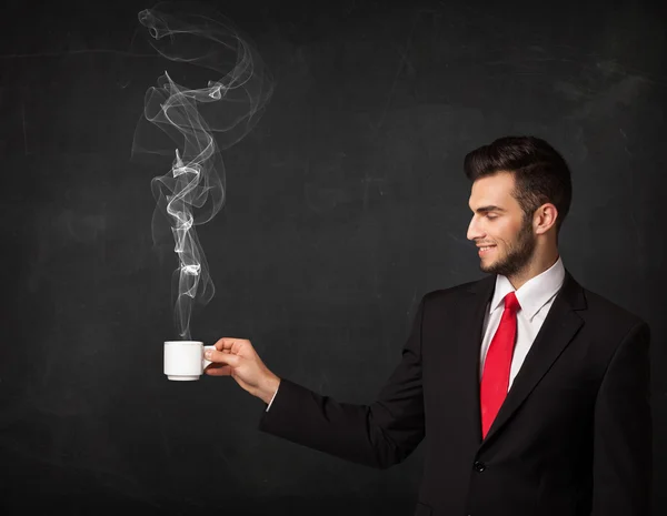 Businessman holding a white steamy cup — Stock Photo, Image