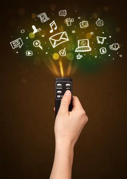 Hand with remote control and social media icons — Stock Photo, Image