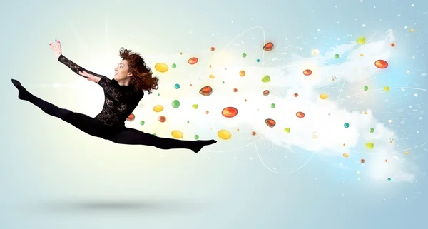 Beautiful woman jumping with colorful gems and crystals on the b