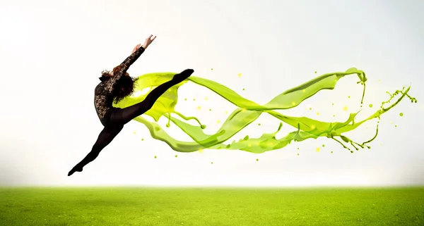 Hezká dívka skákání se zelenou abstraktní tekuté šaty — Stock fotografie